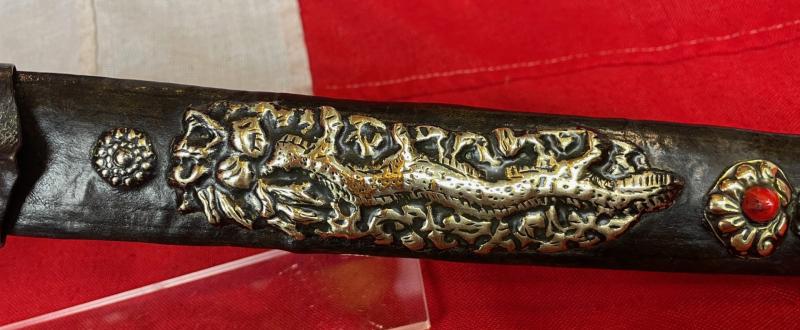 A Most Interesting & Unusual Form of Antique Tibetan Buddhist Large Dagger-Short Sword. A Dpa'dam. Decorated With Repousse Dragon and Buddha, Seated in the Padmasana Pose, in Dhyana Mudra, With Mandorla, a Coral Stone Bead Inset & Unalome Spiral Sun